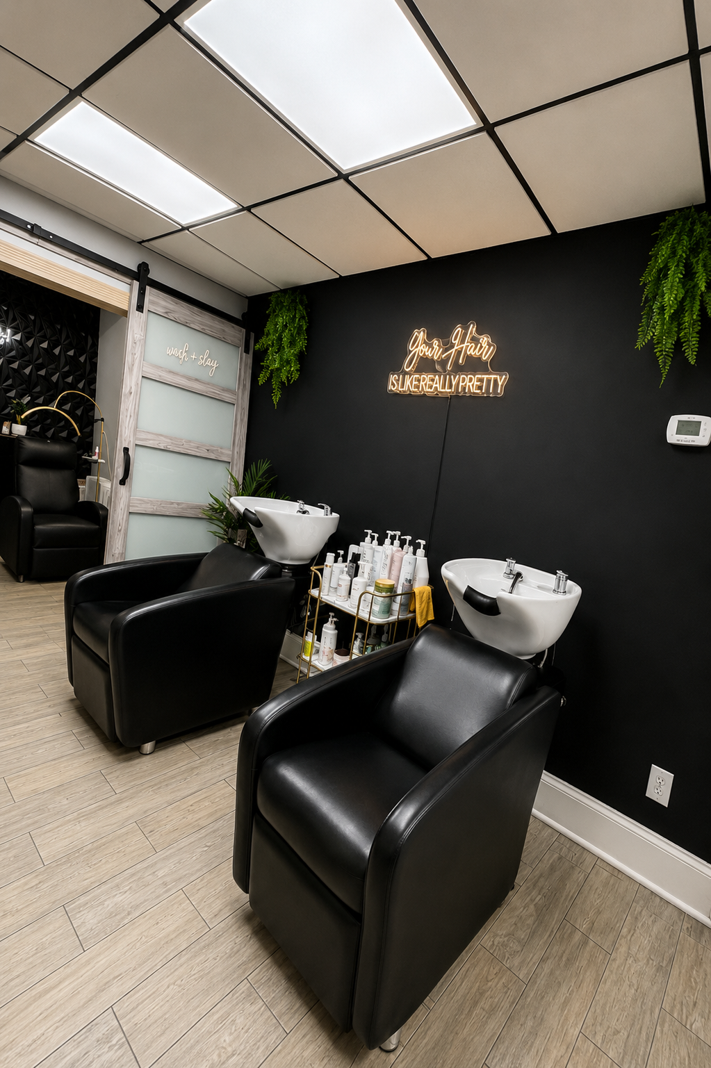 Hair washing station with black chairs and white sinks